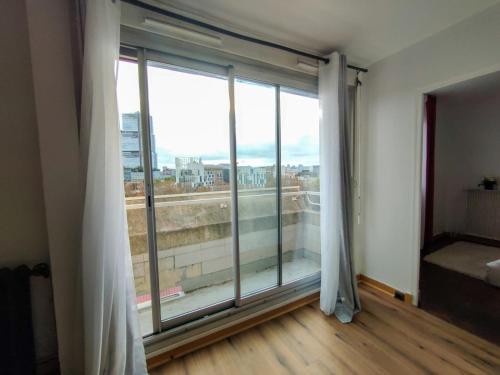 a room with a large window with a view at Le Balcon Victor Hugo - Clichy Paris in Clichy