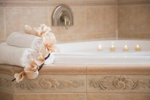 a bathroom with a tub and towels on a counter at Villa Grande - Apartmány in Olomouc