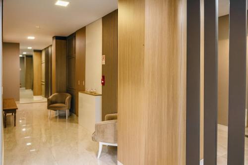 a lobby with a hallway with chairs at Eleganz Suítes Exclusive Centro in Gramado