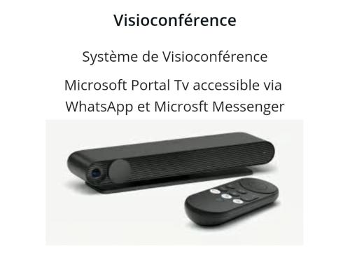 a remote control next to a remote control tv accessible via whatsapp at microsoft at Rez de jardin & Salle de réunion in La Ferrière