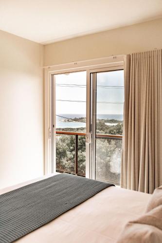 a bedroom with a bed and a large window at Diamond Skies in Bicheno