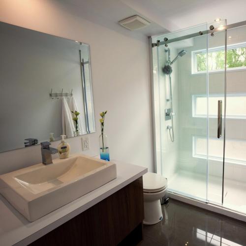 a bathroom with a sink and a glass shower at Marina Port de Québec 2 - Maison flottante in Quebec City