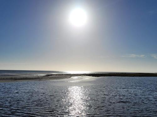 a body of water with the sun in the sky at 6 person holiday home in Hadsund-By Traum in Øster Hurup