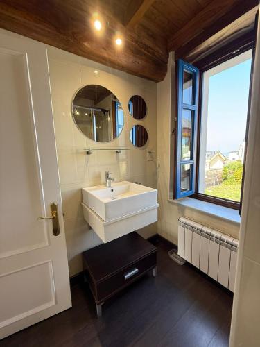a bathroom with a sink and a mirror and a window at Casa Chita in Tapia de Casariego