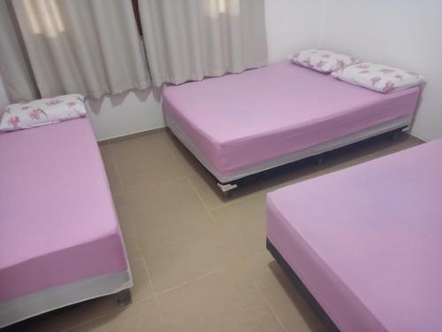 3 camas en una habitación con sábanas moradas en Casa para temporada Amargosa-ba, en Amargosa