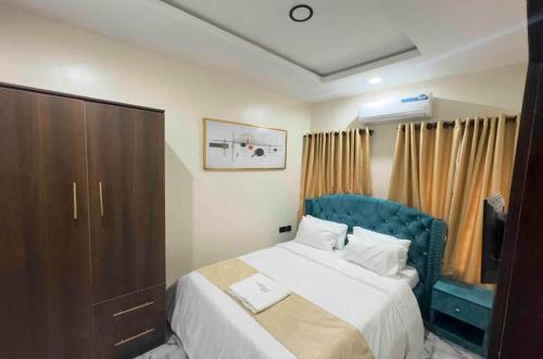 伊凯贾La Vintage Apartelle - Apartment Singapore的卧室里有一张带蓝色床头板的大床