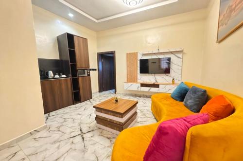 伊凯贾La Vintage Apartelle - Apartment Singapore的客厅配有黄色沙发和电视