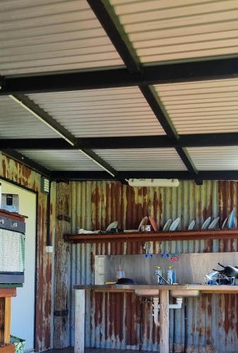 an old room with rusted walls and wooden shelves at One Life Live It Farm stay in Dareton