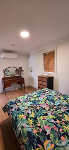 a bedroom with a bed and a dresser and a window at One Life Live It Farm stay in Dareton