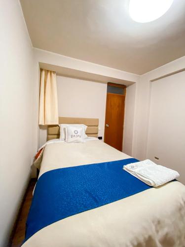 a small bedroom with a blue and white bed at QAIPU HOTEL in Puquio