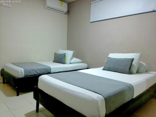 two beds in a hotel room with at Hotel Casa Boston Inn by Finerh in Barranquilla