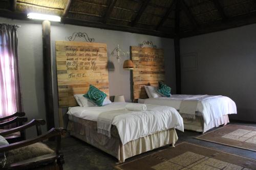 a bedroom with two beds and a wall at Makarios Lodge in Polokwane
