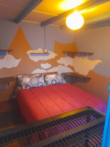 a bedroom with a bed with a red comforter at La Casa EcoExplor in San Pedro de Atacama