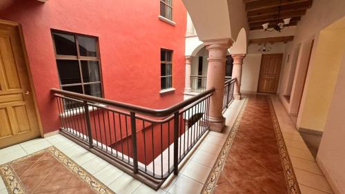 a balcony with a red wall and a black railing at Hotel San Rafael in Querétaro