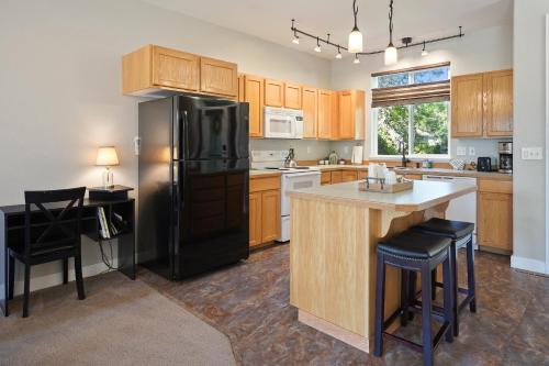 a kitchen with a black refrigerator and a counter at Present Pheasant home in Redmond