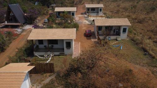 une vue aérienne d'une maison sur une colline dans l'établissement Chale Esmeralda Conforto Lago Natural Sossego - no melhor da Lapinha da Serra, à Santana do Riacho