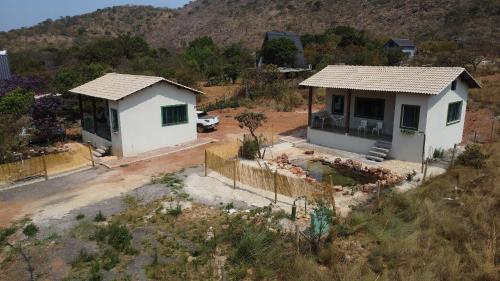 une vue aérienne d'une maison dans un champ dans l'établissement Chale Esmeralda Conforto Lago Natural Sossego - no melhor da Lapinha da Serra, à Santana do Riacho