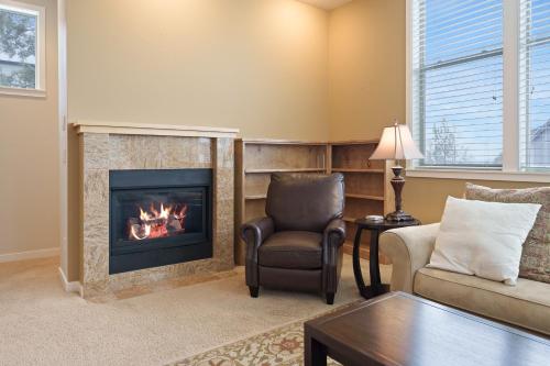 a living room with a fireplace and a chair at Presidio Park home in Redmond