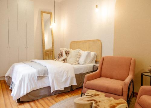a bedroom with a bed and a chair at Kin Pech Roma by Capitalia in Mexico City