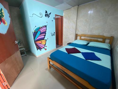 a bedroom with a bed with a butterfly painted on the wall at Fauna in Santa Marta