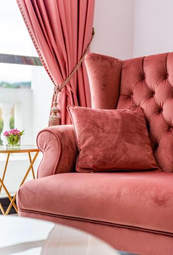 a red couch with a red curtain in a room at Olivia Boutique Hotel in Sanxing
