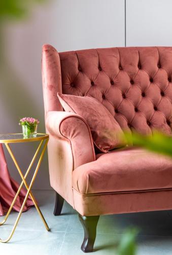 a pink couch sitting next to a side table at Olivia Boutique Hotel in Sanxing