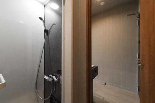 a bathroom with a shower with a glass door at Hotel Yatsu in Komatsu