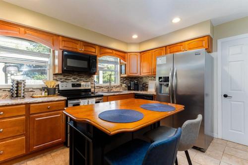 a kitchen with a wooden table and a refrigerator at The Dome Home - 3BR House 1mi to ND in South Bend