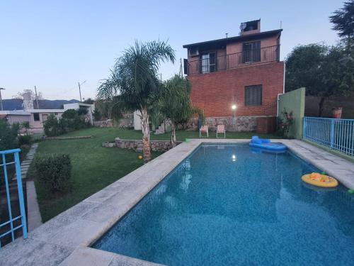 ein Swimmingpool vor einem Haus in der Unterkunft Casa en las Sierras de Cordoba in Villa Parque Siquiman