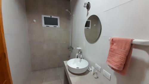 a white bathroom with a sink and a mirror at Sol de Abril in Russell