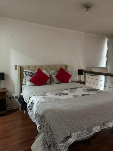 a bedroom with a large bed with red pillows at Loft Rousse Travel in Santiago