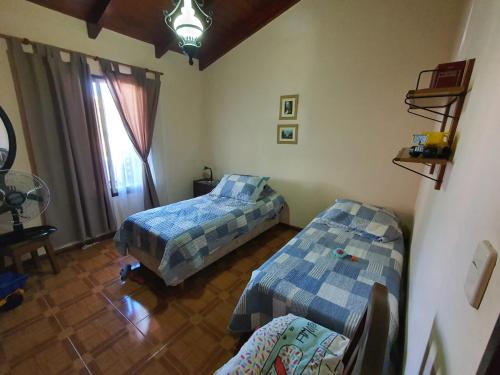 ein Schlafzimmer mit zwei Betten und einem Fenster in der Unterkunft Casa en las Sierras de Cordoba in Villa Parque Siquiman