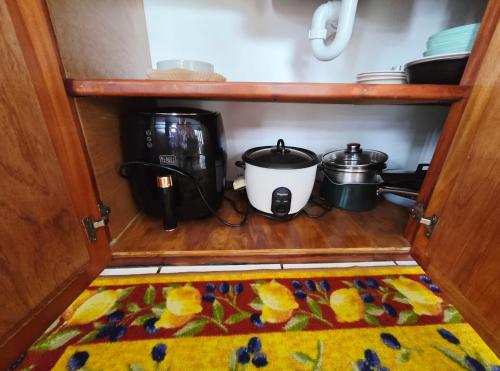 a cabinet with two pots and a coffee maker and a rug at Ocean Breeze Villa in Savusavu