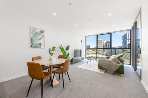 a living room with a table and chairs and a couch at Central Woden Stay, Near Hospital, CIT, Pool in Phillip