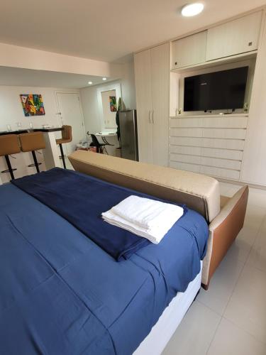 una camera da letto con un letto grande con lenzuola blu e una TV a schermo piatto di Flat Lakeside Beira lago a Brasilia