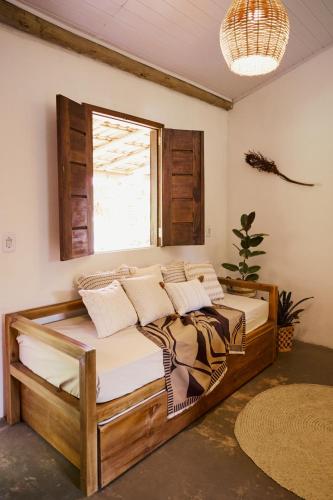 a bed in a room with a window at Vila Três - A apenas 2 minutos da praia! in Caraíva