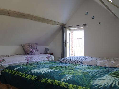 ein Schlafzimmer mit zwei Betten und einem Fenster in der Unterkunft Charme champêtre entre Le Mans et Tours, maison rénovée en pleine nature - FR-1-410-480 in Flée