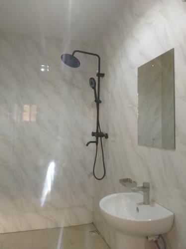 a shower in a bathroom with a sink and a mirror at Aquarian Spring Homes in Ikeja