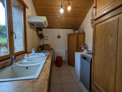 a kitchen with a tub and a sink and a washer at Charmant meublé au calme, proche cascades, randos, chevaux, parking et terrasse privée, WiFi gratuit - FR-1-589-365 in Le Tholy