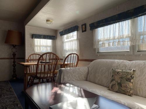 un soggiorno con un divano, un tavolo e delle sedie di Camp inn Kiyosato GRANDEUR - Vacation STAY 42079v a Hokuto