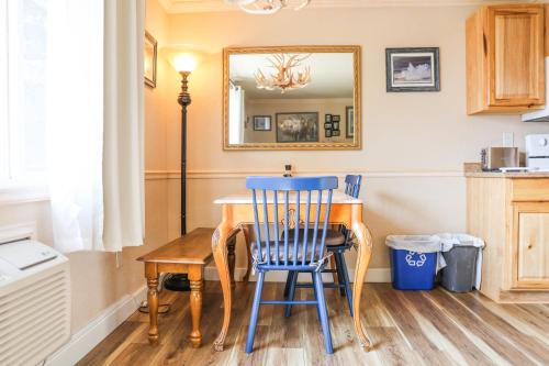 a dining room table with a blue chair and a mirror at Yellowstone Gateway Inn in Gardiner
