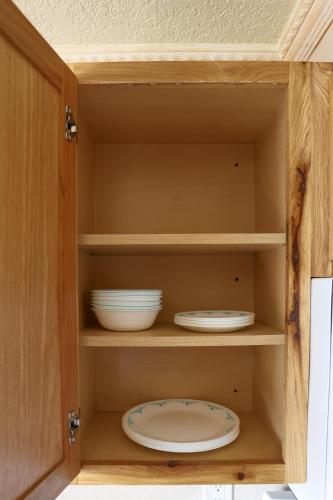 a cupboard with plates and bowls in it at Yellowstone Gateway Inn in Gardiner