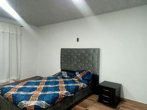 a bedroom with a bed with a blue comforter at la terraza in Armenia