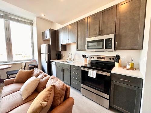 a living room with a couch and a kitchen at Deer District Studio Apt - One Block from Fiserv and Baird in Milwaukee