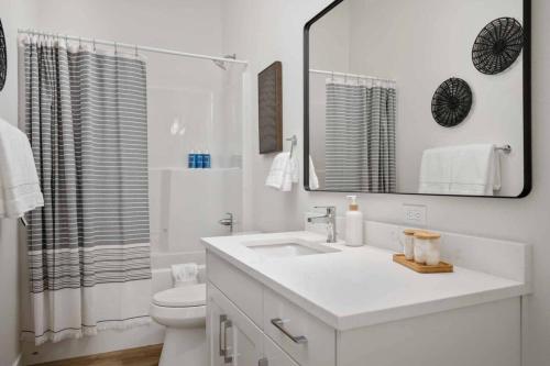 a bathroom with a sink and a toilet and a mirror at Ebb920 Modern Loft, Heart of Taft District in Lincoln City