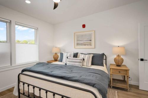 a bedroom with a bed and two lamps and a window at Ebb920 Modern Loft, Heart of Taft District in Lincoln City