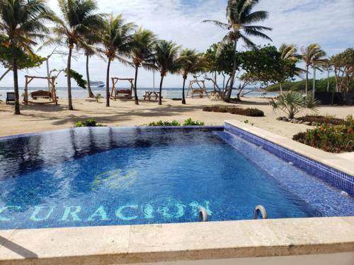 a swimming pool with the beach in the background at Curacion Beach Resort in Brick Bay