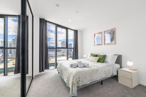 a white bedroom with a bed and large windows at Stylish Woden 2BR, Near Hospital, CIT, Westfield in Phillip
