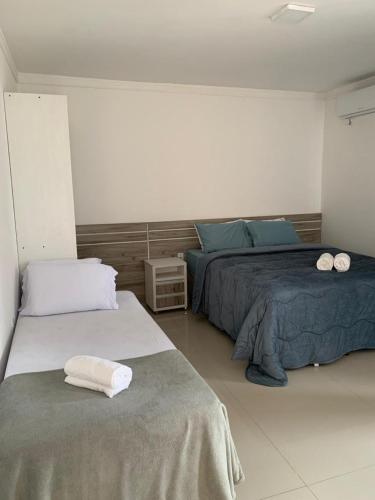 a bedroom with two beds with towels on them at Pousada VÔ REY in Penha
