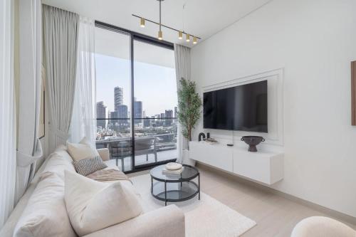 a living room with a white couch and a large window at Free housekeeping visits during your stay - StayShort - Luxury 2BR with Private Pool & Skyline Terrace JVC in Dubai